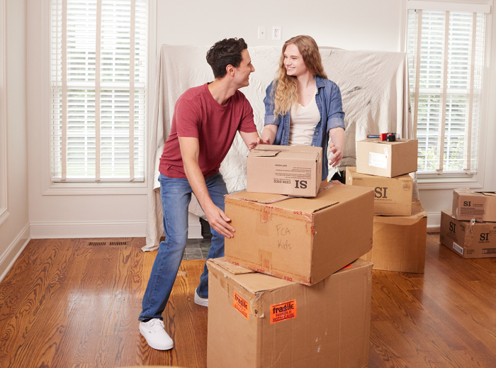 Young couple unpacking boxes in their new home
