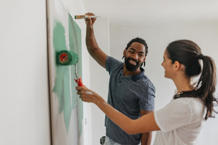 Young couple painting walls in their home