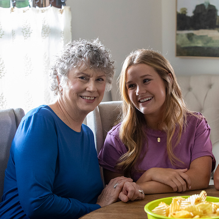 Grandma sitting by granddaughter.