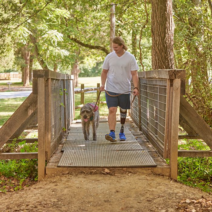 Man walking his dog on a hike.