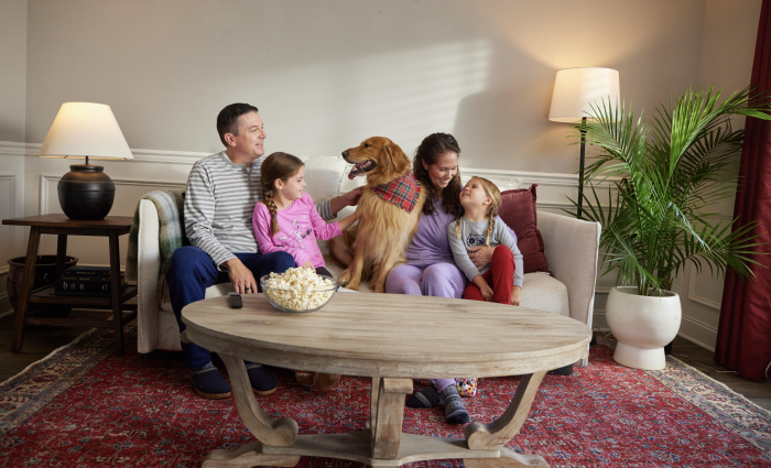 family with dog relaxing on couch