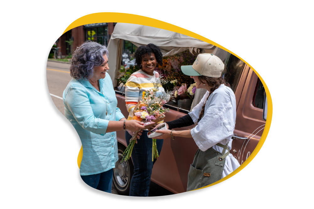 Woman buying flowers from a flower cart