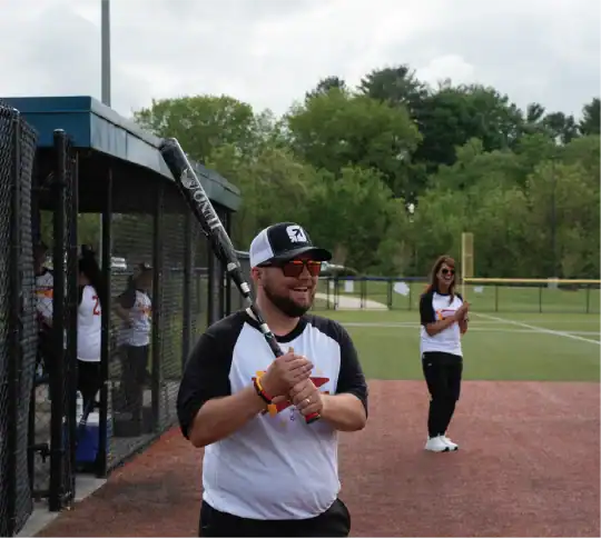 KTVAECU Employee holding a bat at a softball game