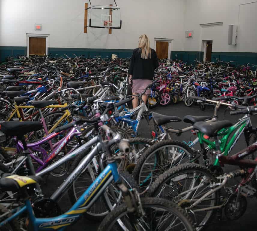 Woman walking through rows of donated bikes