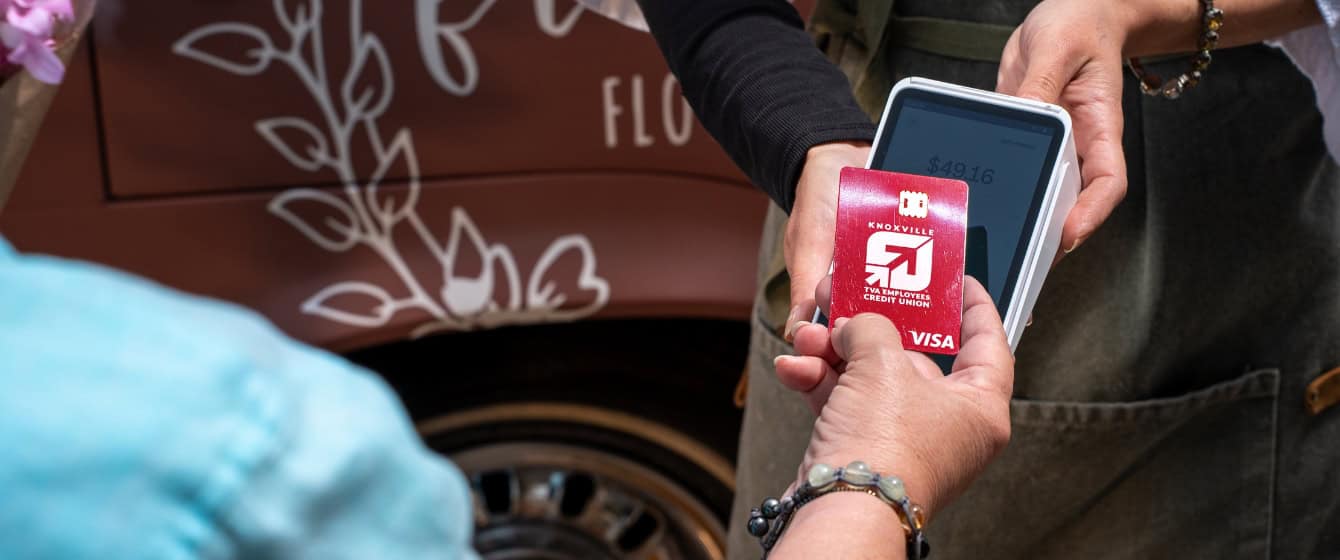 Woman tapping KTVAECU Credit Card on payment terminal