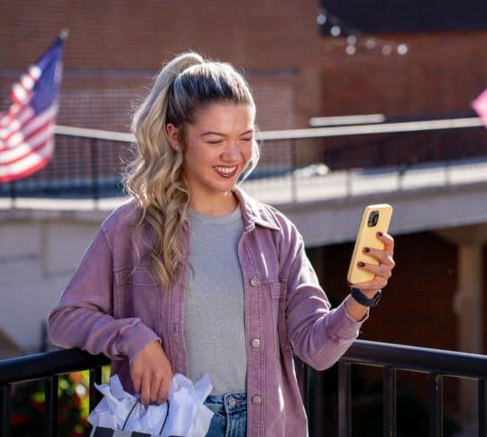 Girl smiling and looking at her cell phone