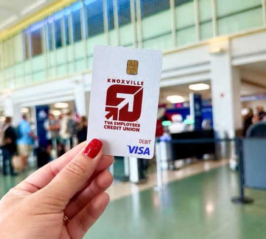 Image of a debit card being held up in an airport
