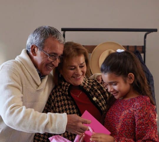 Older couple and young girl exchanging card