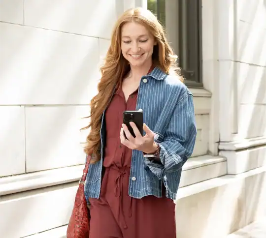 Girl holding phone and walking down the street