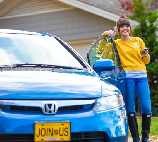 Girl standing next to car with keys