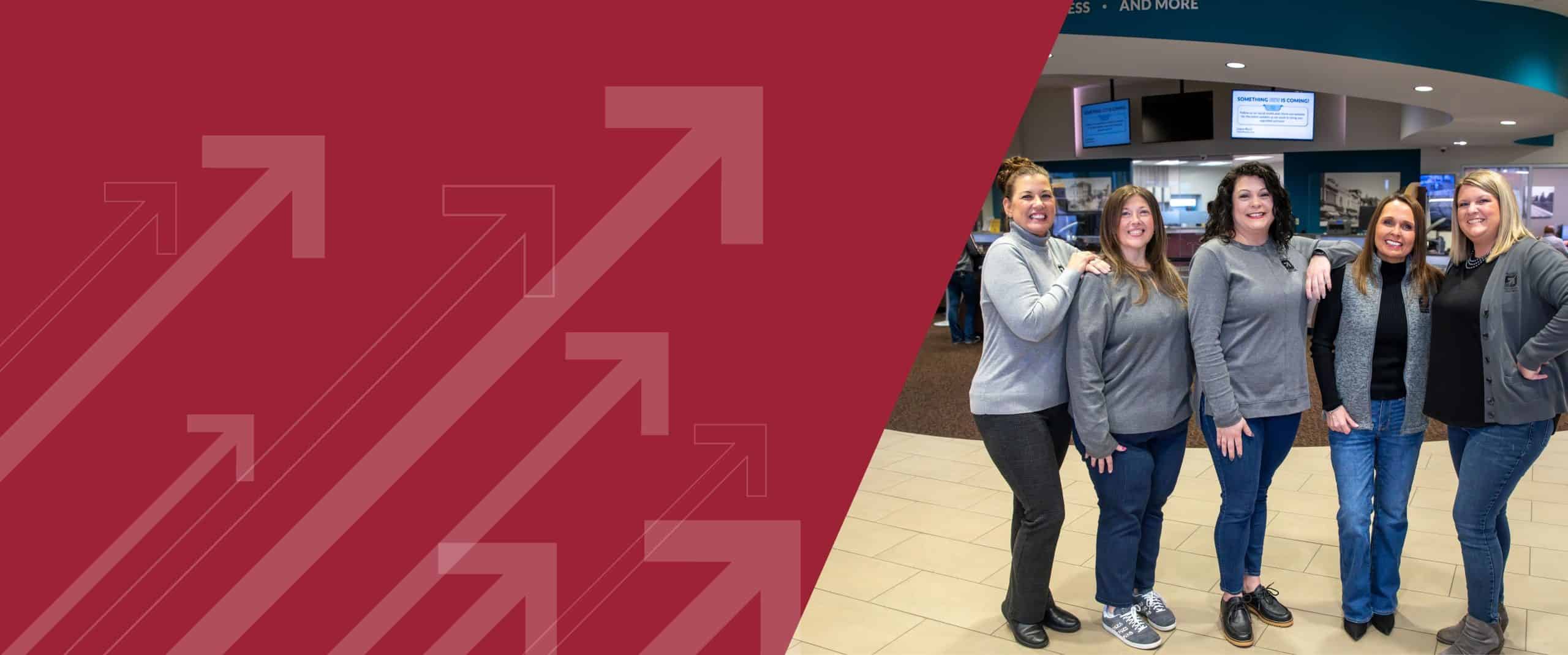 Group of loan officers standing in a branch and smiling