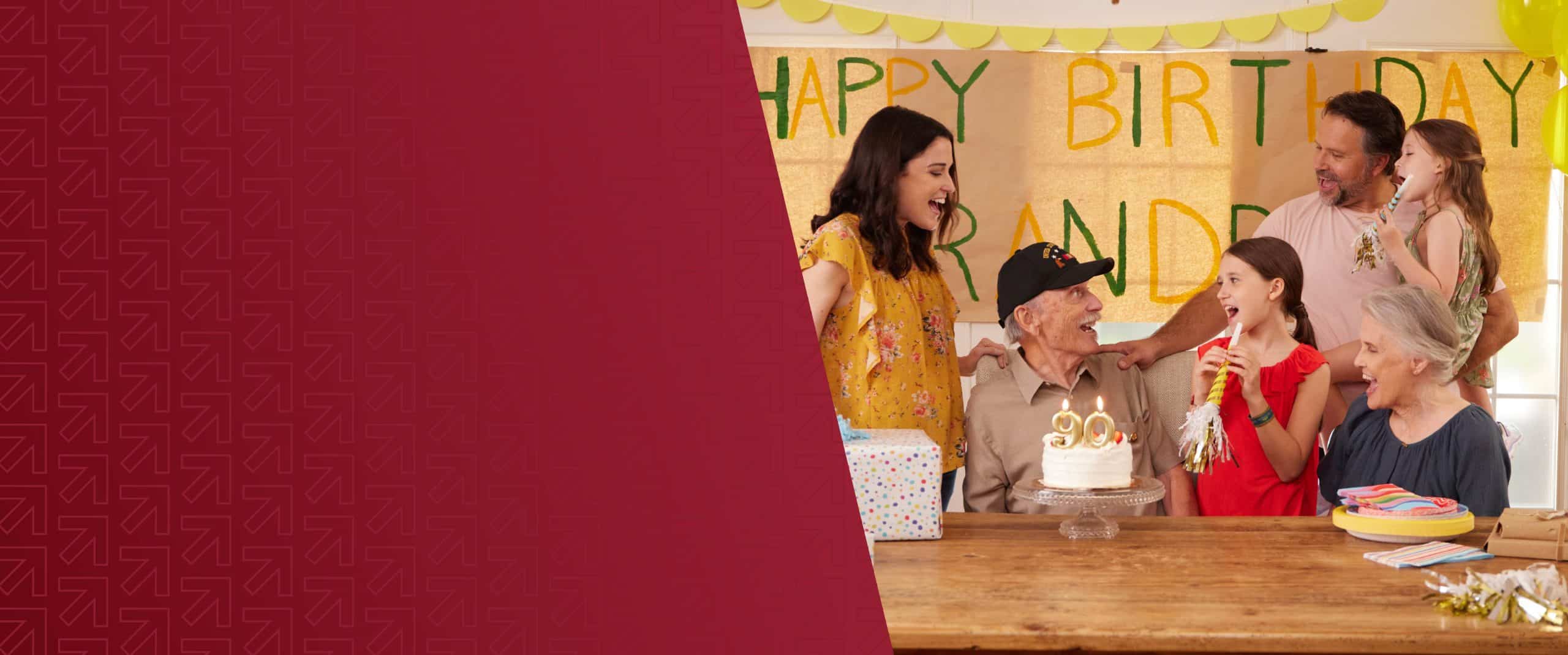 Family celebrating birthday with cake and gifts at a party.