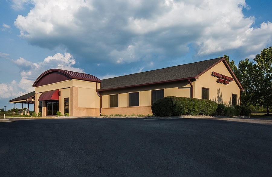 KTVAECU Alcoa Branch with a curved roof and red awning under a cloudy sky.