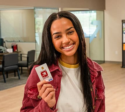 Girl holding a KTVAECU Debit Card.