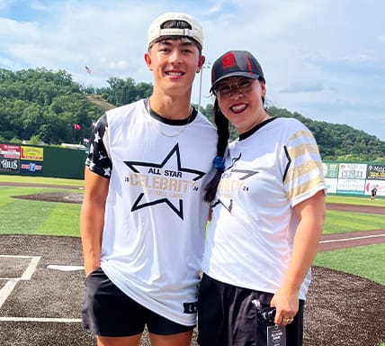 Employee smiling and standing on a baseball field for a picture