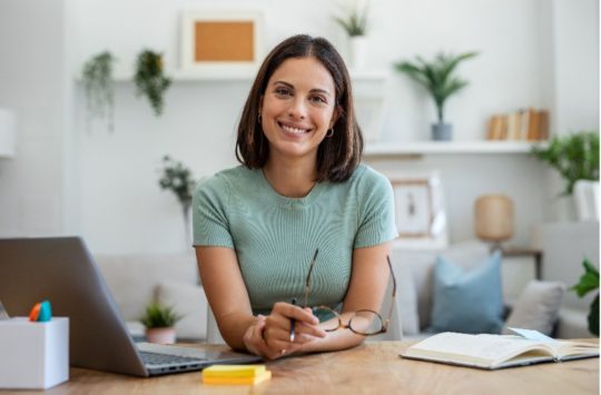 Woman sitting at desk smiling at the camera
